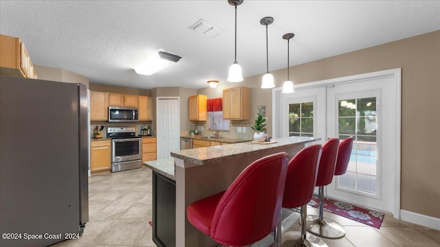 kitchen with a breakfast bar area, stainless steel appliances, sink, kitchen peninsula, and decorative backsplash