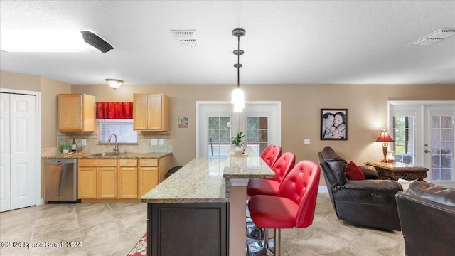 kitchen with stainless steel dishwasher, sink, decorative backsplash, and french doors