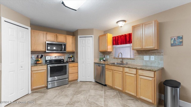 kitchen with light brown cabinetry, sink, appliances with stainless steel finishes, and decorative backsplash