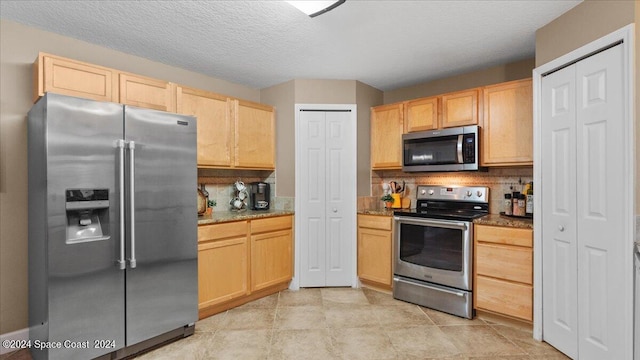 kitchen featuring appliances with stainless steel finishes, backsplash, light tile patterned floors, and light brown cabinets