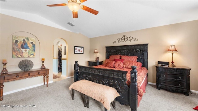 carpeted bedroom featuring ceiling fan, a fireplace, and vaulted ceiling