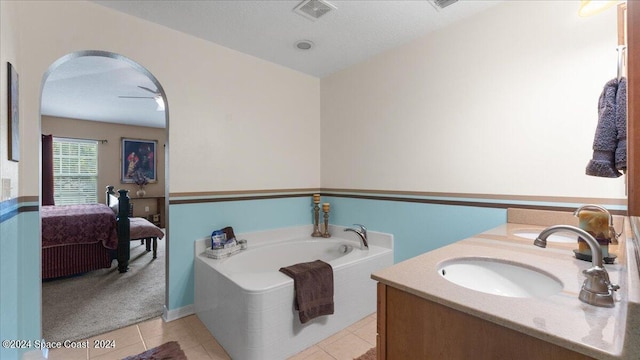 bathroom with a bathtub, vanity, a textured ceiling, and tile patterned floors