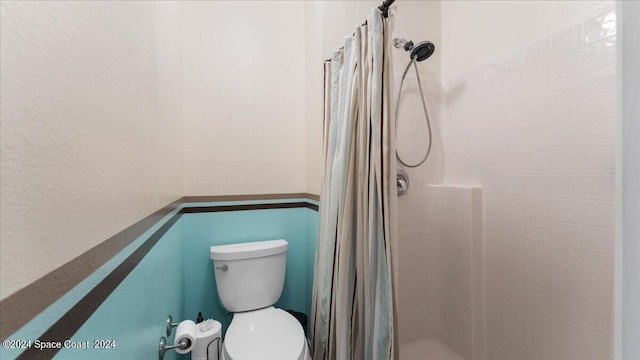 bathroom featuring a shower with shower curtain and toilet