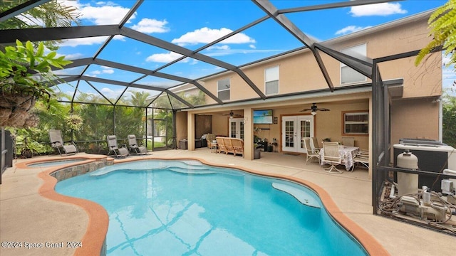 view of pool featuring an in ground hot tub, a patio area, french doors, glass enclosure, and ceiling fan