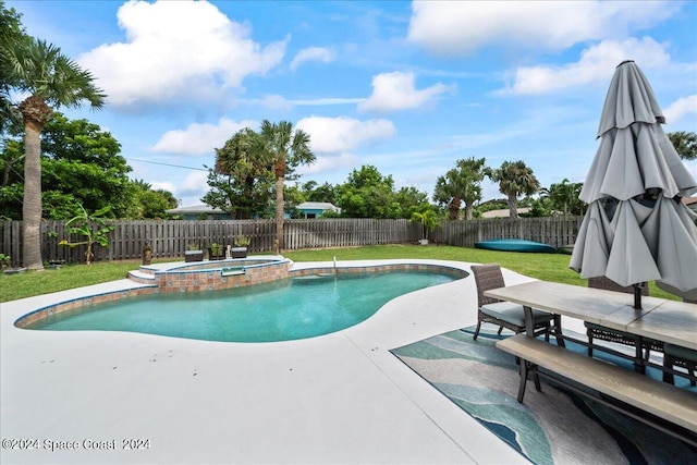 view of pool featuring an in ground hot tub, a lawn, and a patio