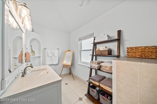 bathroom with lofted ceiling, vanity, and tile patterned floors