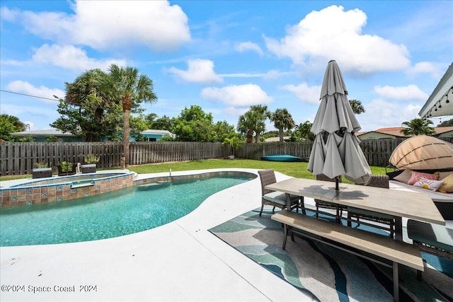 view of pool featuring a lawn, a patio, and an in ground hot tub