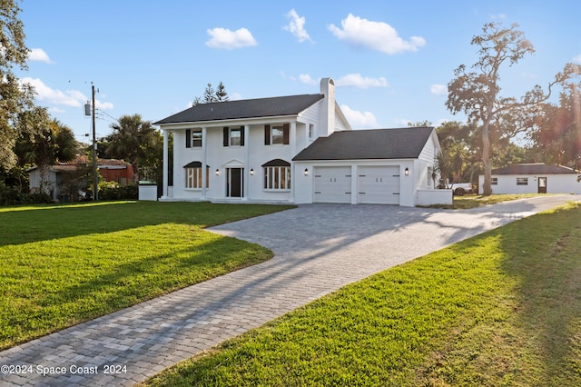 view of front of house with a front yard and a garage