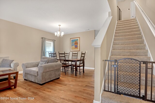 living room featuring a chandelier and light hardwood / wood-style flooring