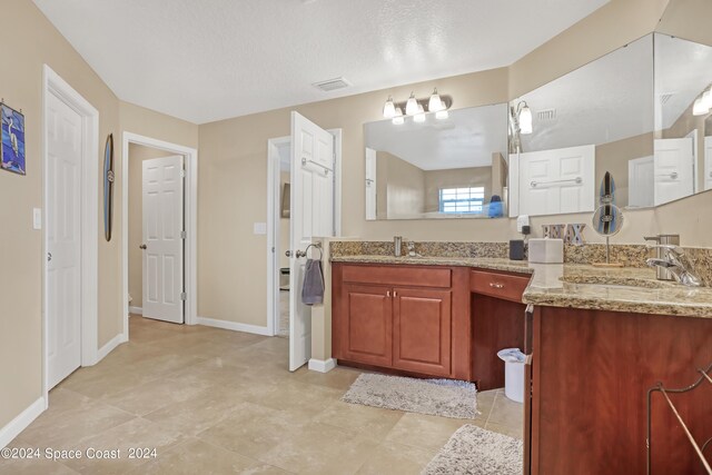 bathroom with vanity and a textured ceiling