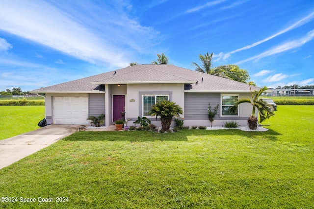 ranch-style home featuring a garage and a front lawn