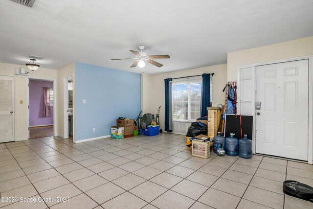 interior space with ceiling fan and light tile patterned flooring