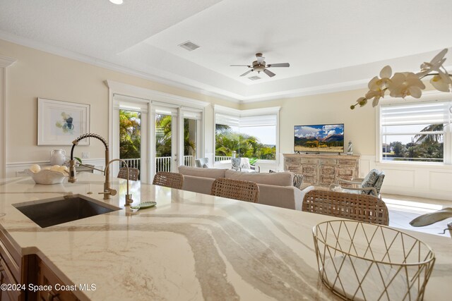 bedroom featuring multiple windows, sink, crown molding, and access to exterior