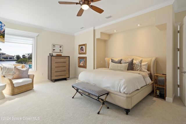 carpeted bedroom featuring ceiling fan and crown molding