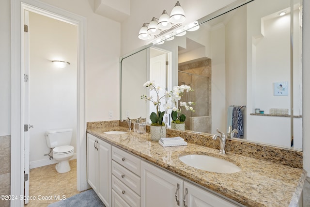 bathroom with toilet, vanity, and tile patterned floors