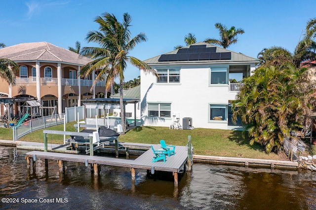 dock area with central AC unit, a lawn, and a water view