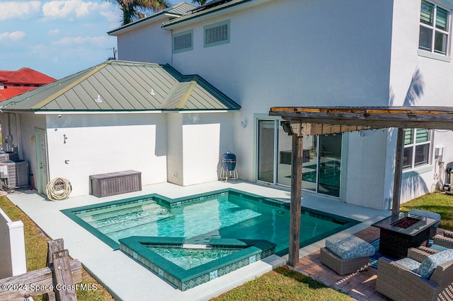 back of property featuring central air condition unit, a patio area, a pergola, and an outdoor fire pit