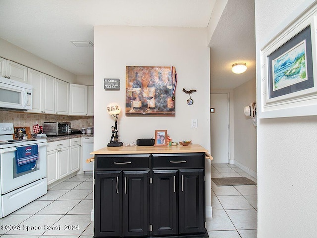 kitchen with white cabinets, white appliances, light tile patterned floors, and backsplash