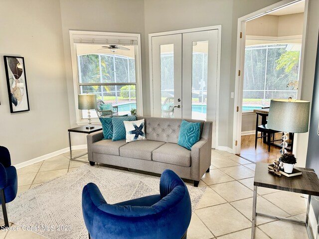 tiled living room with ceiling fan and french doors