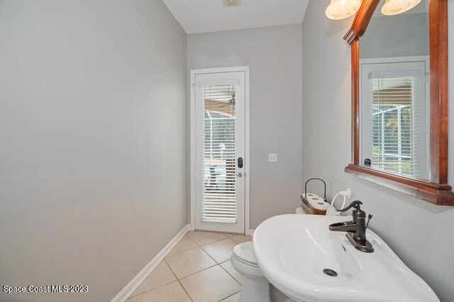 bathroom featuring toilet, sink, and tile patterned floors