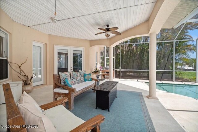 sunroom with french doors, ceiling fan, and a swimming pool