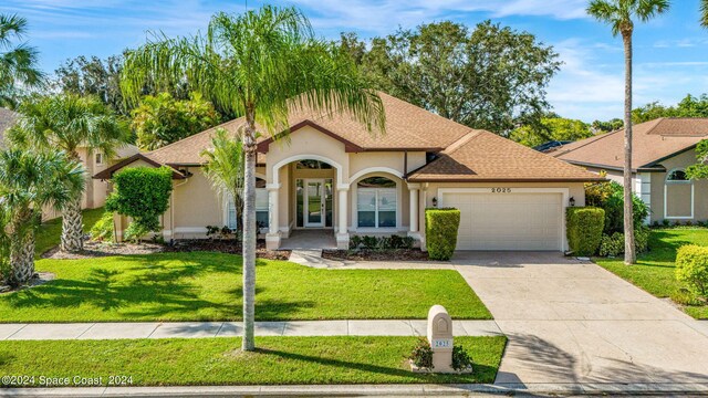 mediterranean / spanish house featuring a garage and a front yard