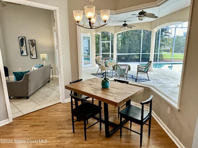 dining space with baseboards, wood finished floors, and a sunroom