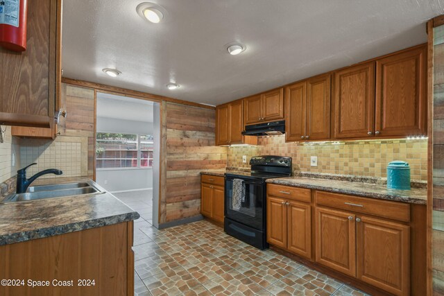 kitchen featuring sink, black / electric stove, and backsplash