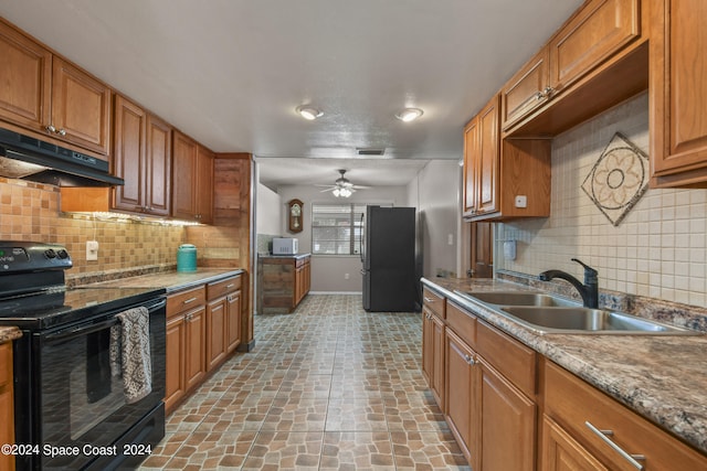 kitchen with black appliances, light stone countertops, ceiling fan, sink, and backsplash