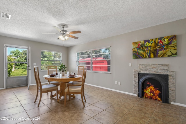 tiled dining area featuring a textured ceiling and ceiling fan