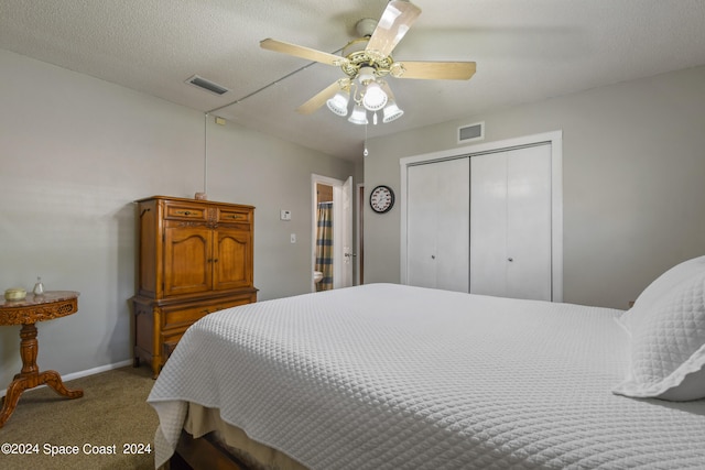 carpeted bedroom with a closet, ceiling fan, and a textured ceiling