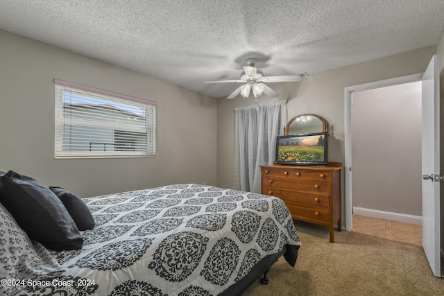 carpeted bedroom featuring ceiling fan and a textured ceiling