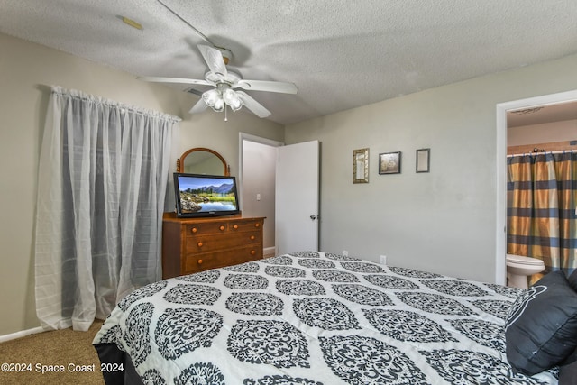 carpeted bedroom featuring ensuite bathroom, a textured ceiling, and ceiling fan