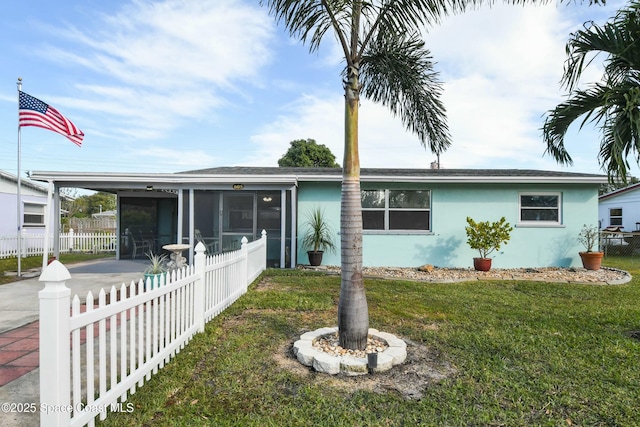 view of front of home featuring a front yard and a sunroom