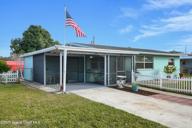 back of property with a lawn and a sunroom