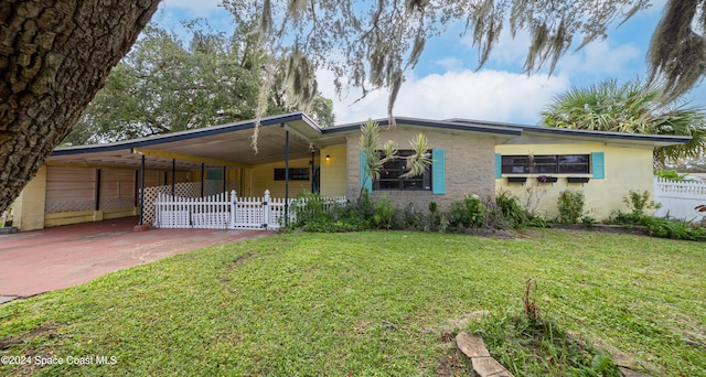 view of front of home with a carport and a front lawn