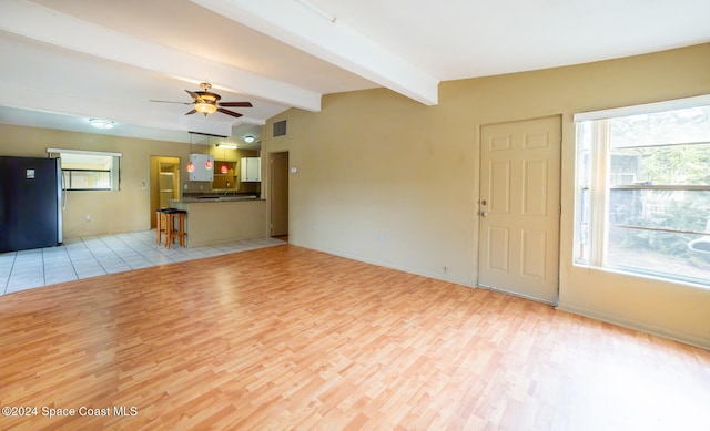 unfurnished living room with light hardwood / wood-style floors, lofted ceiling with beams, and ceiling fan