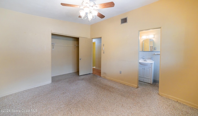 unfurnished bedroom with a closet, ensuite bathroom, and ceiling fan