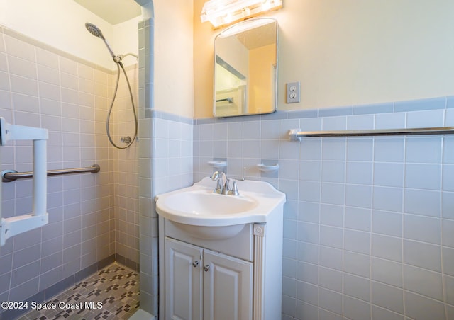 bathroom featuring vanity, tile walls, and tiled shower