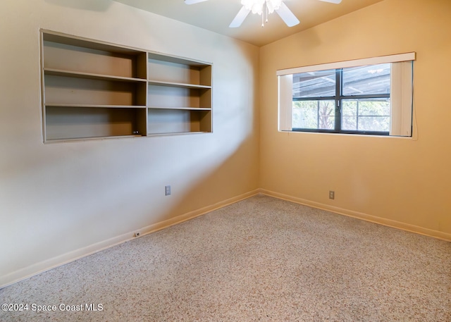 carpeted spare room with ceiling fan and vaulted ceiling