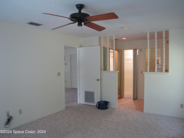 spare room with light colored carpet and a textured ceiling