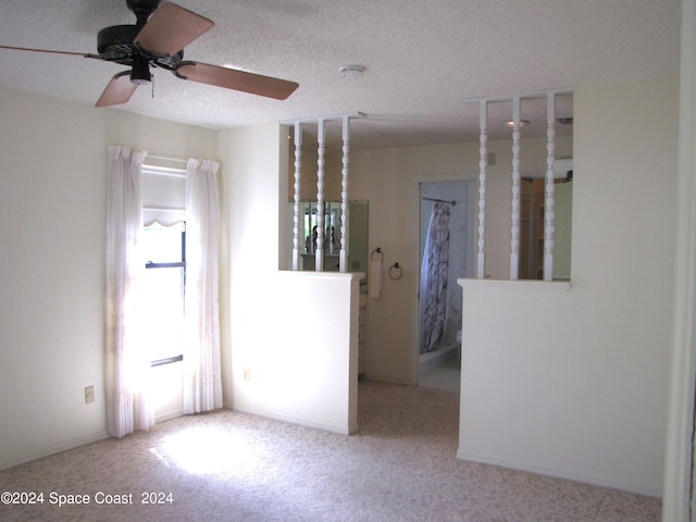 carpeted spare room featuring ceiling fan and a textured ceiling