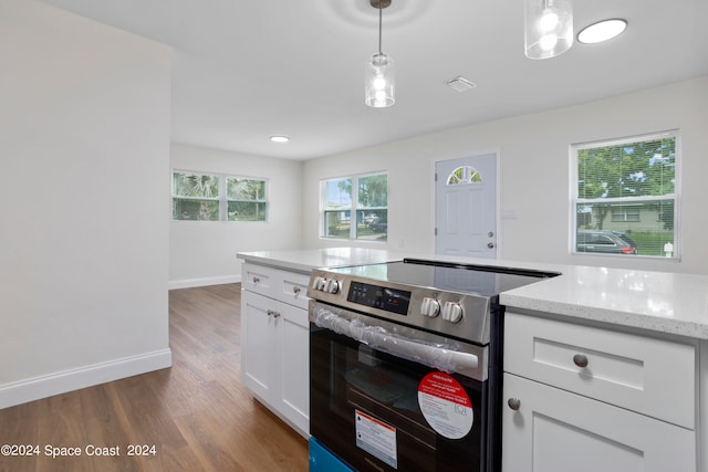 kitchen featuring pendant lighting, white cabinets, light stone counters, dark wood-type flooring, and stainless steel electric range