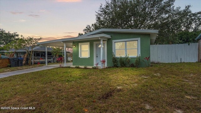 view of front of property with a lawn and a carport