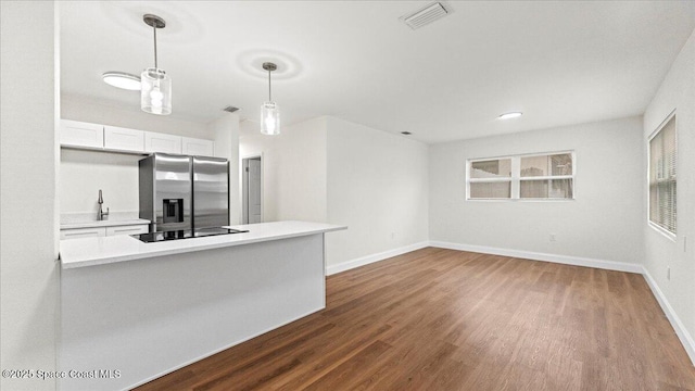 kitchen featuring pendant lighting, white cabinetry, black electric stovetop, stainless steel fridge with ice dispenser, and dark wood-type flooring