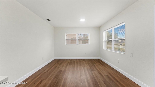 empty room with dark hardwood / wood-style flooring