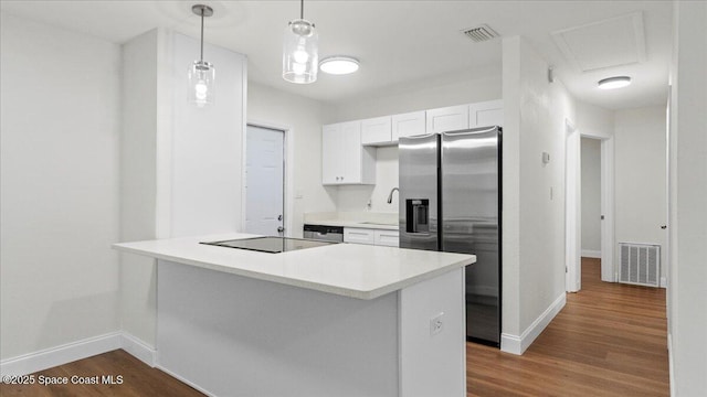 kitchen featuring decorative light fixtures, dark hardwood / wood-style floors, white cabinets, and appliances with stainless steel finishes