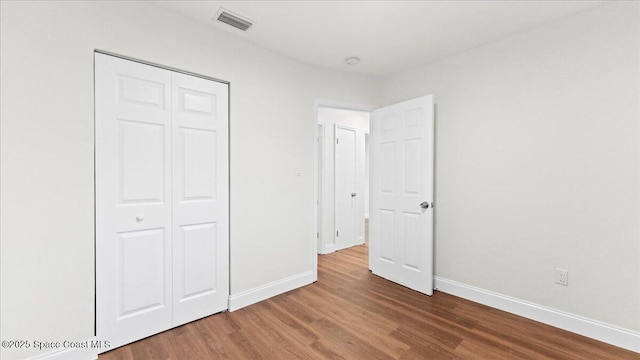 unfurnished bedroom featuring hardwood / wood-style flooring and a closet