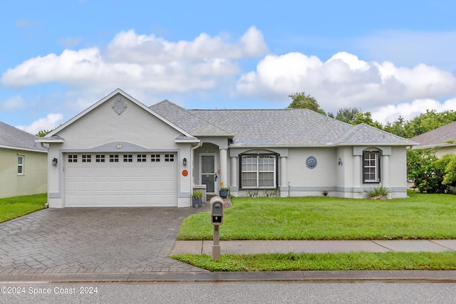 single story home featuring a front lawn and a garage