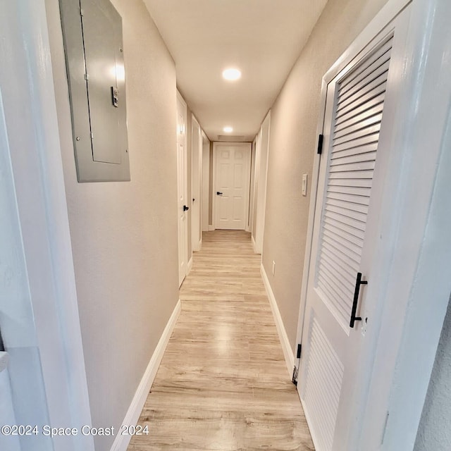 hallway with electric panel and light hardwood / wood-style floors